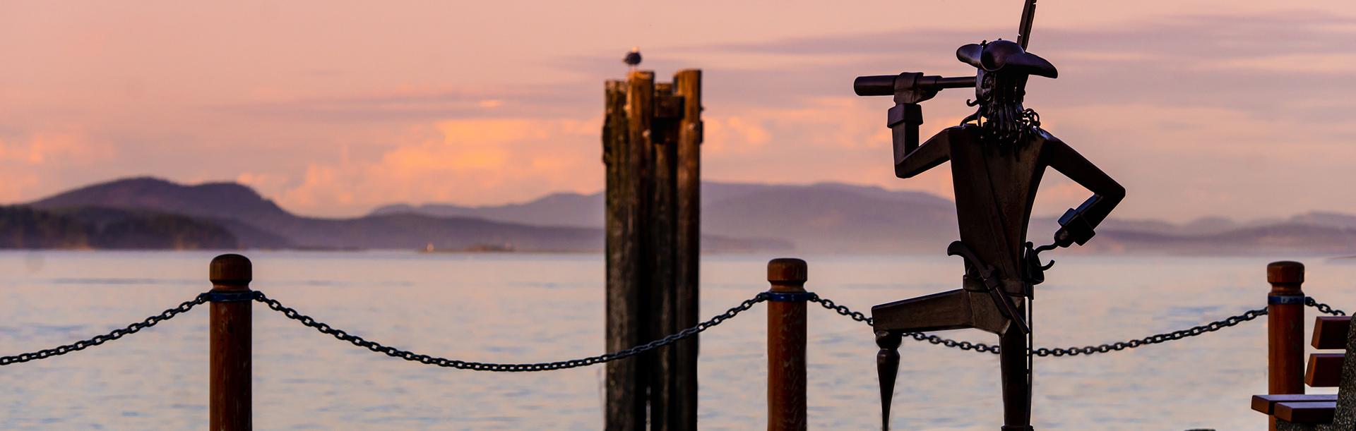 A sculpture of an explorer looks out across the Salish Sea at the Sidney Sculpture Walk in Greater Victoria, BC