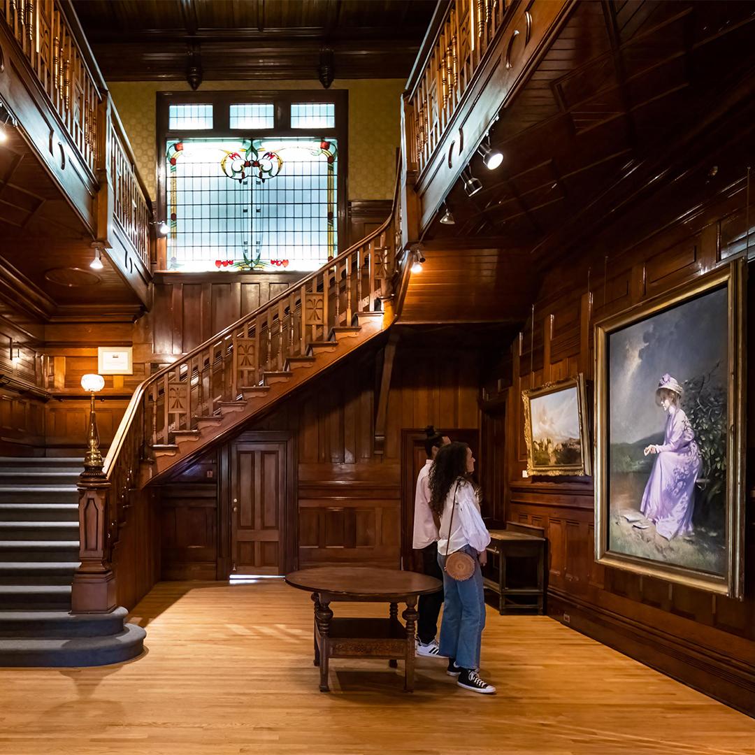 A couple admires the artwork inside the heritage home wing of the Art Gallery of Greater Victoria in Victoria, BC