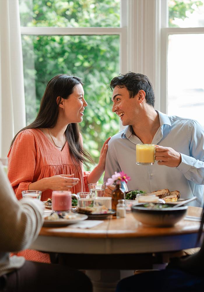 A couple enjoys brunch with their friends at Nourish Kitchen & Cafe in Victoria, BC