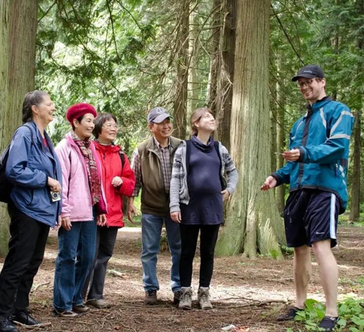 A guide shows visitors some of the plant life within Saanich Parks in Victoria, BC