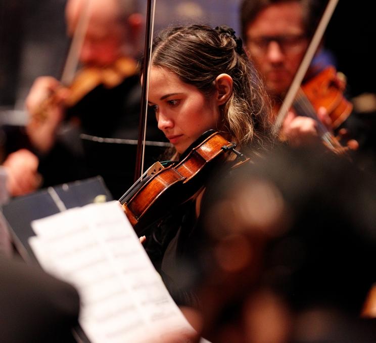 A violinist performs in her orchestra during a performance by the Victoria Symphony in Victoria, BC