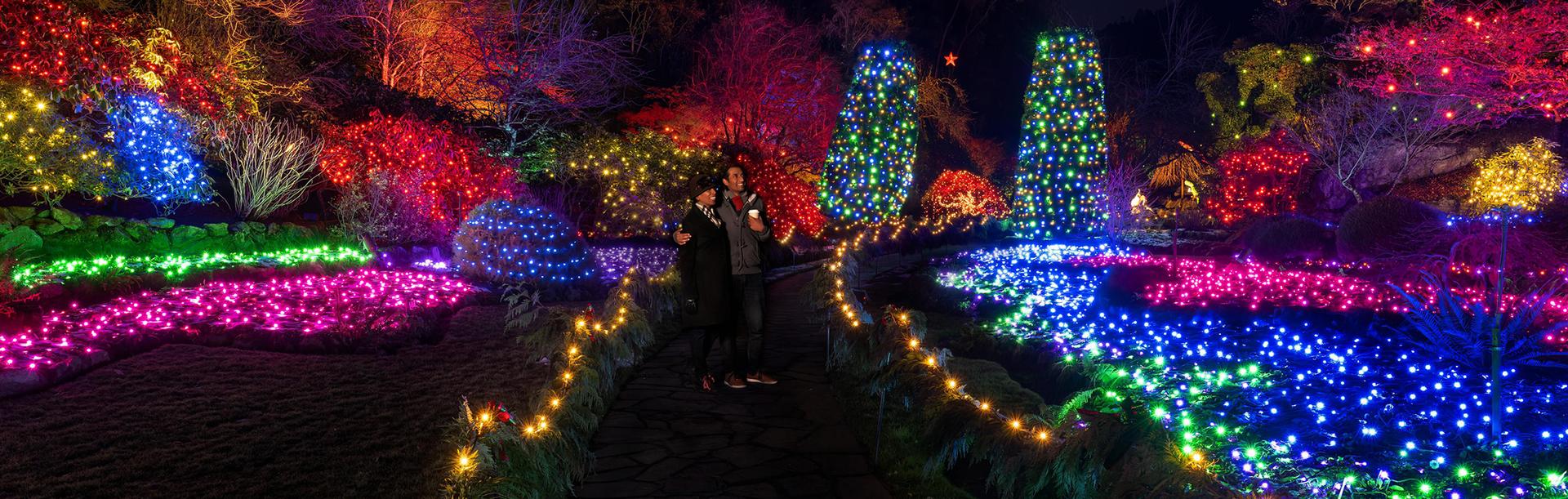 A couple looks out over the Magic of Christmas holiday light display at The Butchart Gardens in Victoria, BC