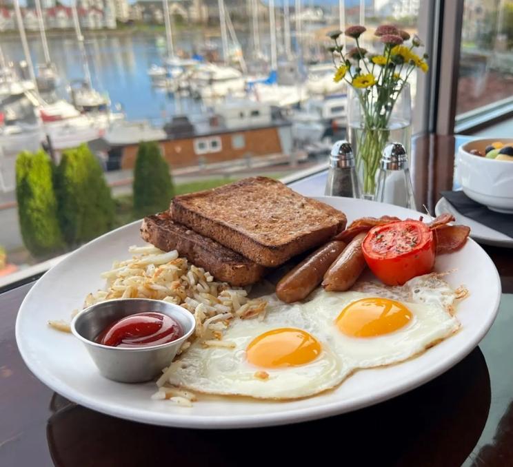 A full breakfast on a table overlooking the Inner Harbour in Victoria, BC