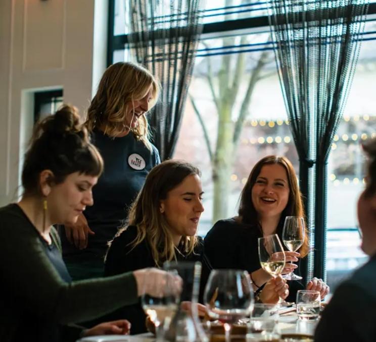 A food tour during an Off the Eaten Track Food Tour enjoys a glass of wine in Victoria, BC