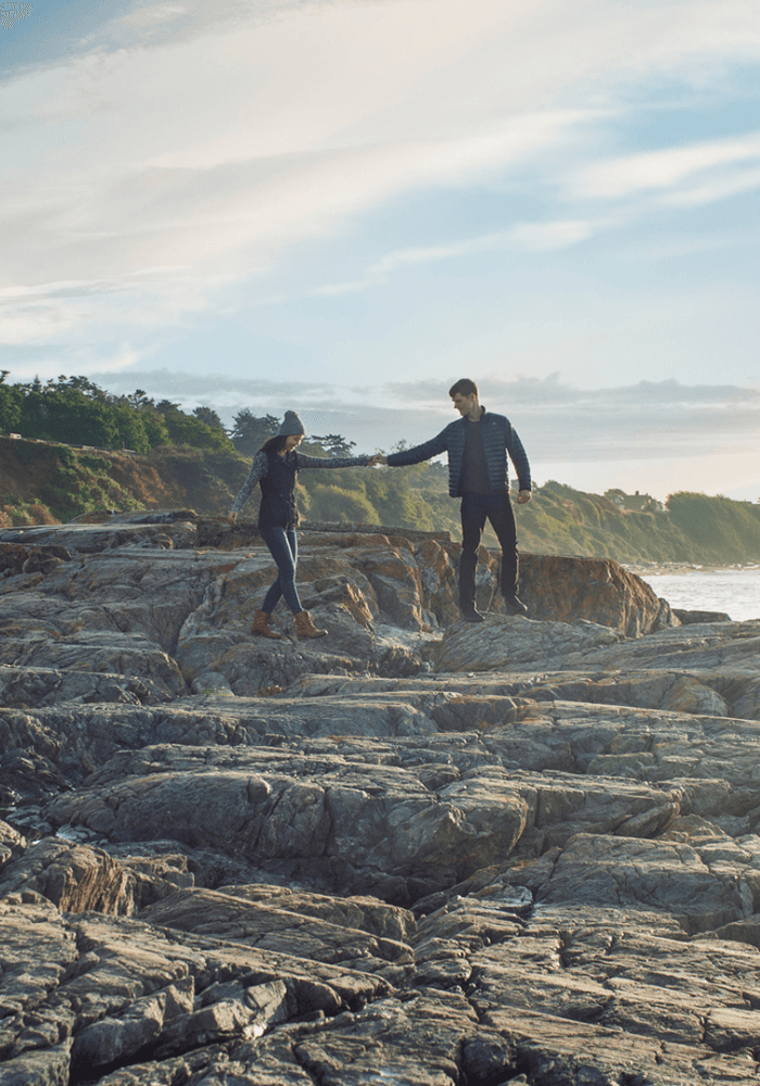 Couple walk hand in hand along Dallas Beach in Victoria, BC