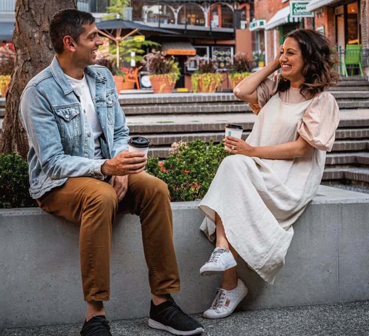 A couple has a conversation while enjoying coffee in Market Square in Victoria, BC
