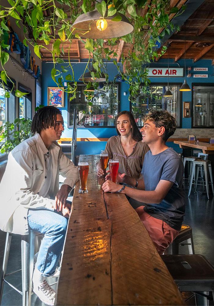 A group of three friends enjoying beer at Phillips Brewing & Malting Co.'s tasting room in Victoria, BC