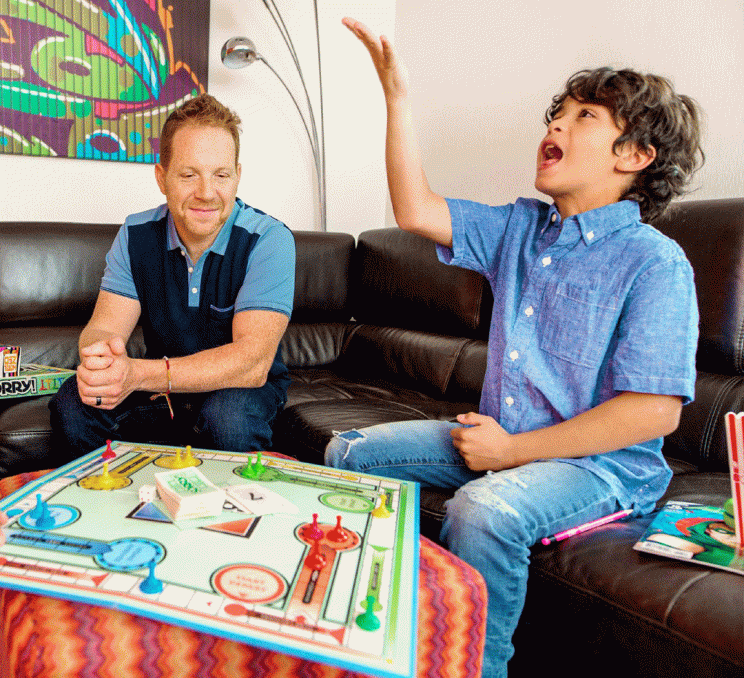 A father and son play board games and eat popcorn inside their room at Hotel Zed in Victoria, BC