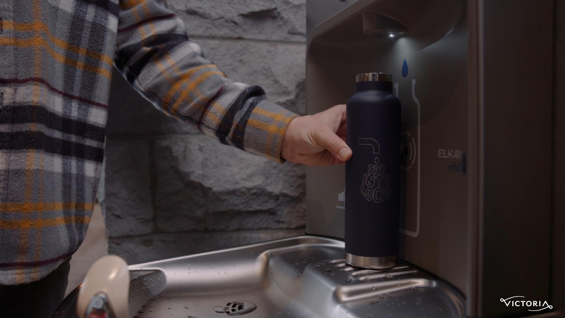 A person fills their Tap into Local water bottle at the Parkside Hotel & Spa's water bottle refill station in Victoria, BC