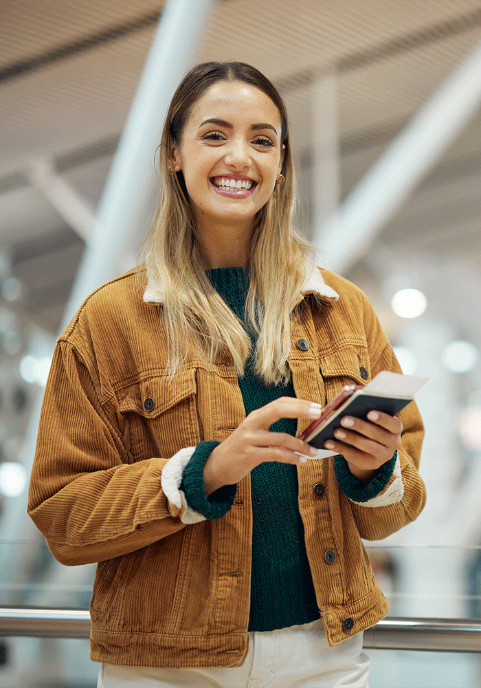 A woman in an airport holding a US passport