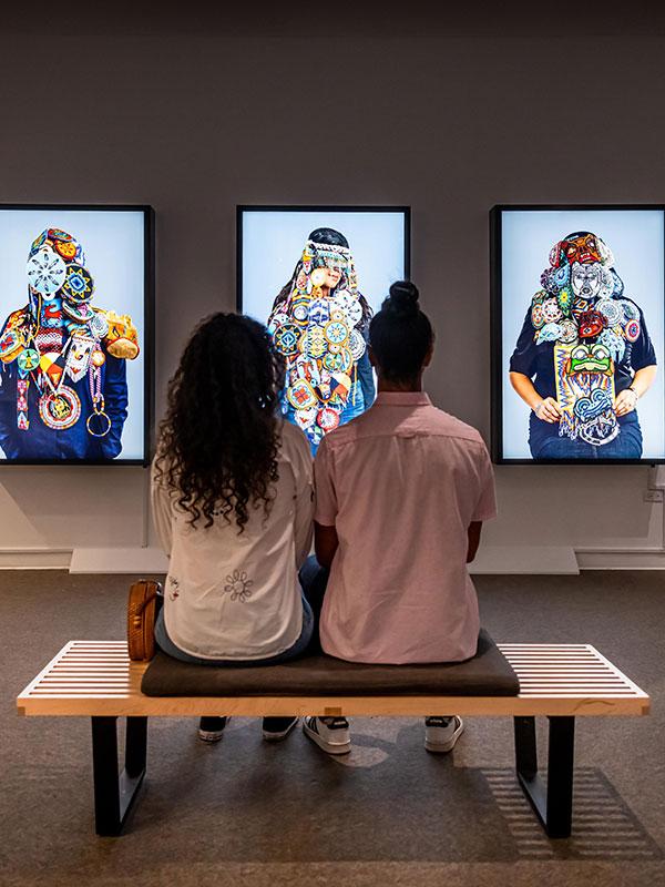 A couple visiting the Art Gallery of Greater Victoria sits down to view some art in Victoria, BC
