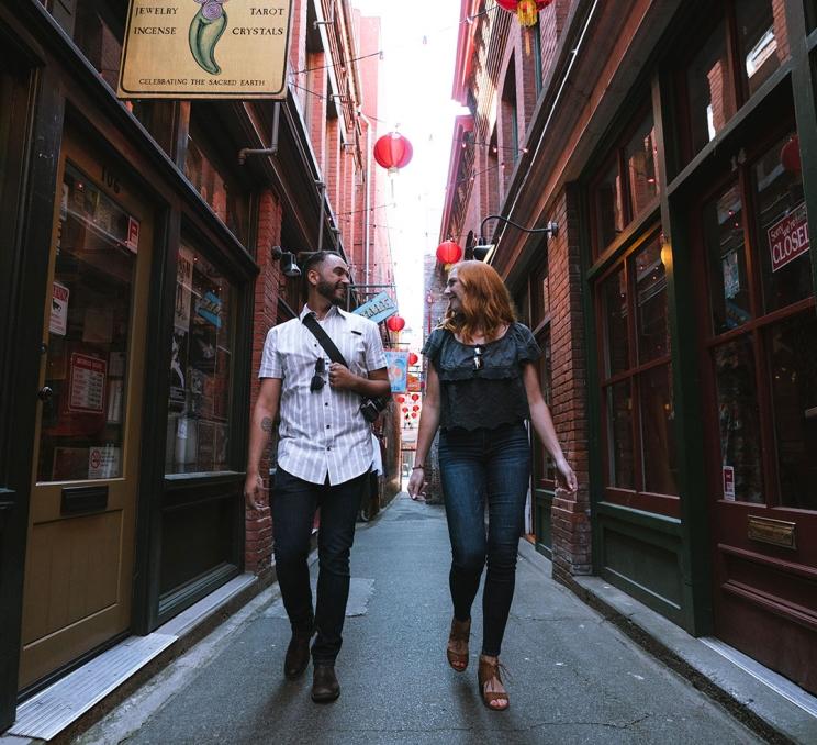 A couple walks down Fan Tan Alley in Victoria, BC's Chinatown