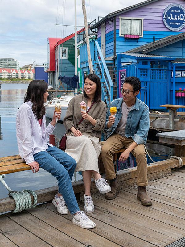 A family eats ice cream cones on the dock at Fisherman's Wharf in Victoria, BC