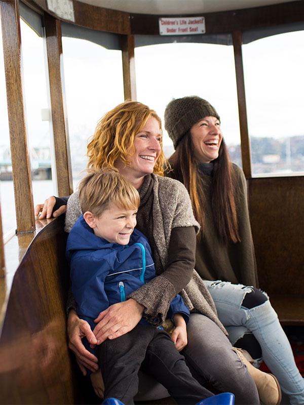 A female couple and their child ride the Victoria Harbour Ferry