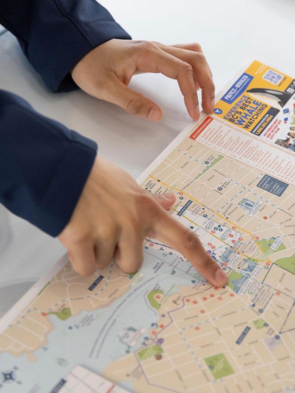 A Victoria Visitor Centre staff member points to a location on a map