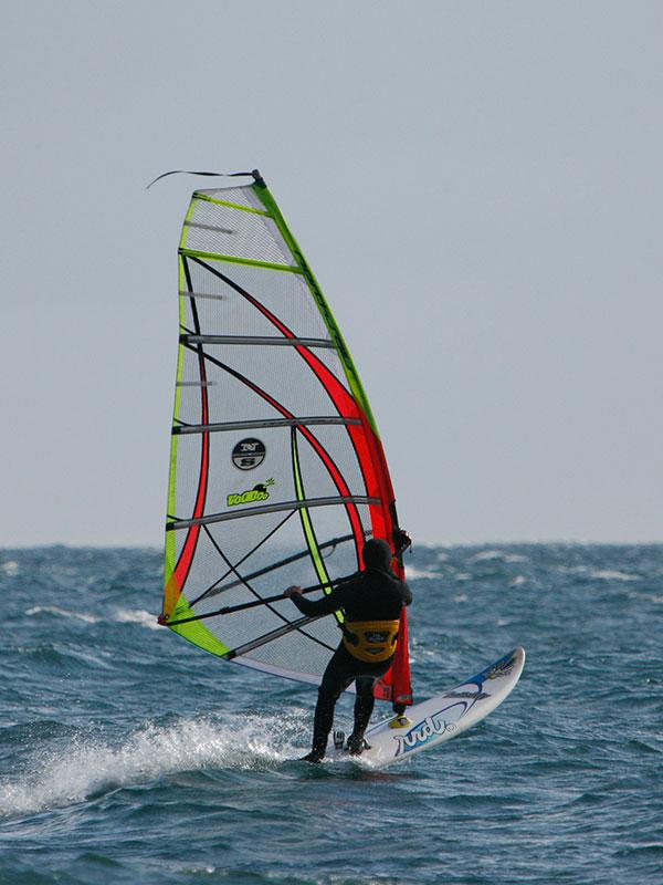 A windsurfer sails across the waves off the coast of Dallas Road in Victoria, BC