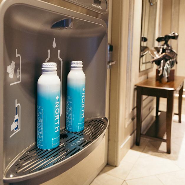 Two water bottles resting on a water bottle refill station inside the Chateau Victoria Hotel & Suites in Victoria, BC