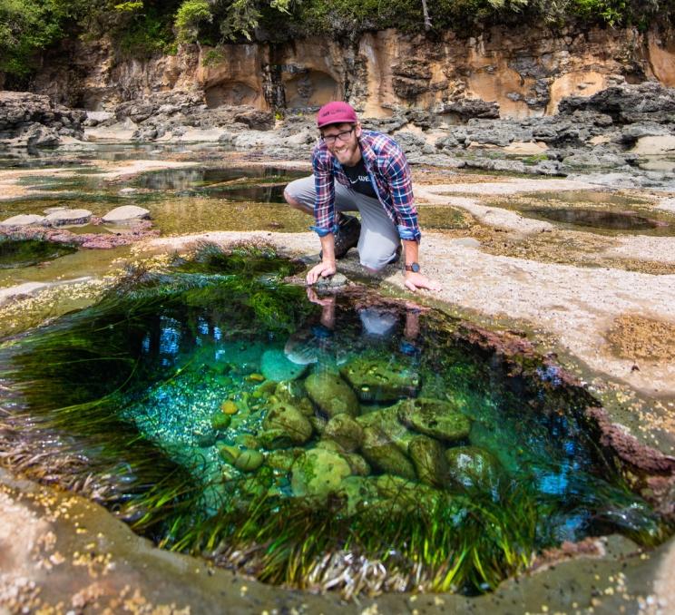A man explores a tidepool at Botanical Beach outside of Victoria, BC
