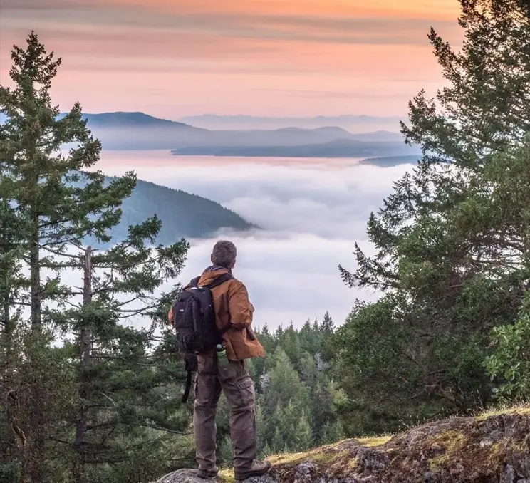 A hiker looks out across the clouds at the Saanich Inlet in Greater Victoria, BC