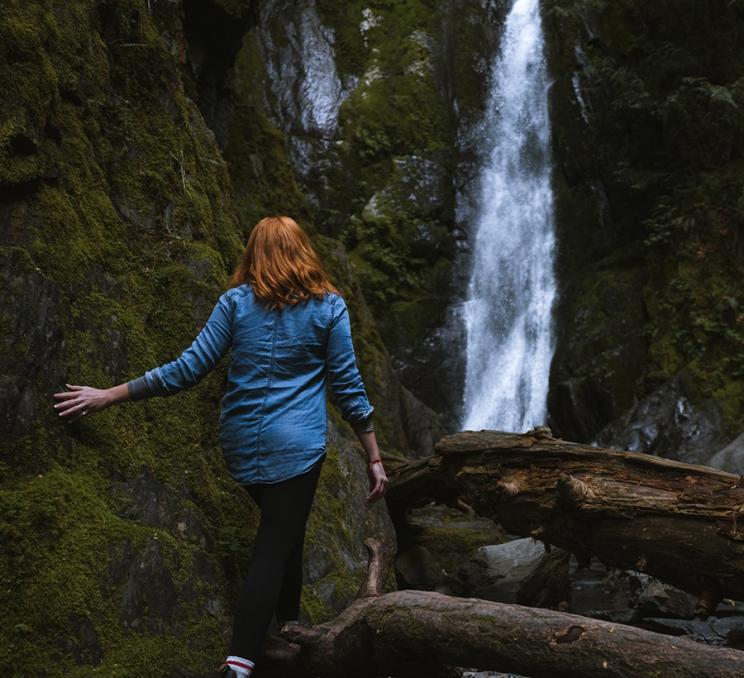 A woman walks towards Niagara Falls at Goldstream Provincial Park in Victoria, BC