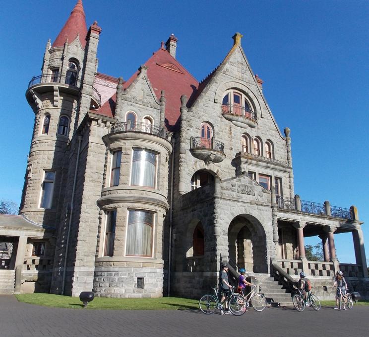 A bike tours outside of Craigdarroch Castle, a National Historic Site, in Victoria, BC