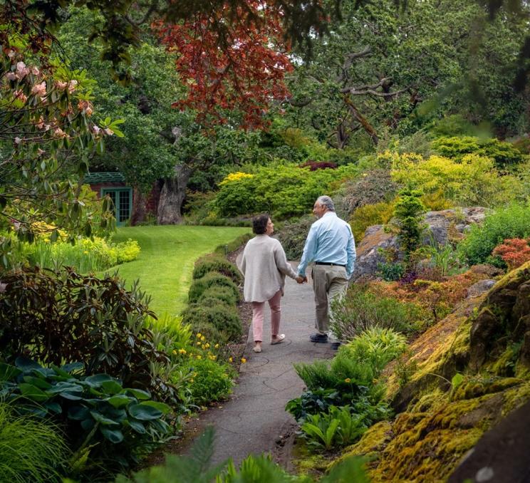 A couple walks hand-in-hand through Abkhazi Garden in Victoria, BC