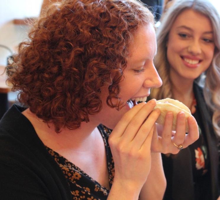 A woman bites into a taco on an Off the Eaten Track Food Tour in Victoria, BC