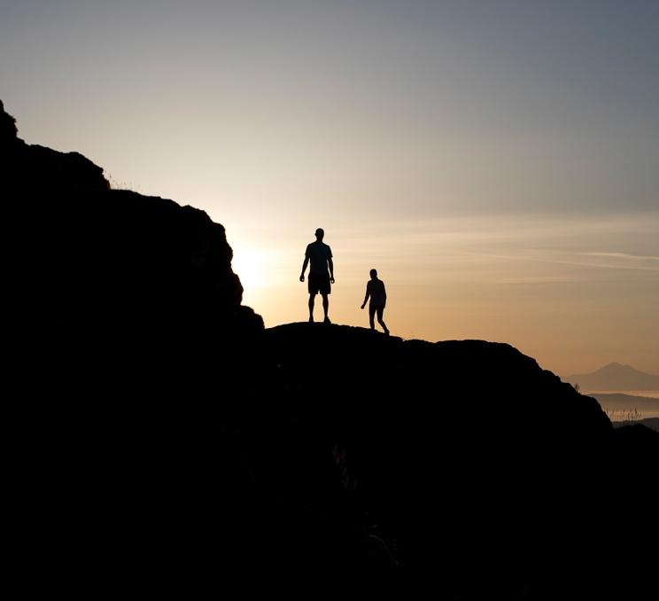 Two people enjoy a sunrise hike up Mount Finlayson in Victoria, BC