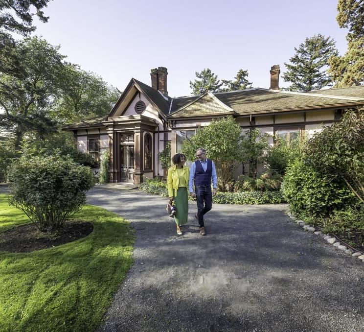 A couple walks hand-in-hand through the garden at Point Ellice House in Victoria, BC