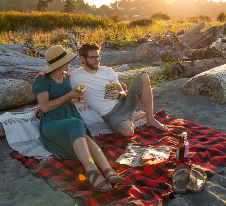 A young couple enjoys a beach picnic in Victoria, BC