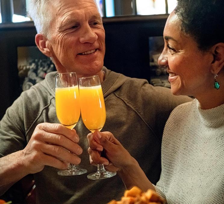 A couple drinks mimosas and enjoys brunch at the Bard & Banker in Victoria, BC