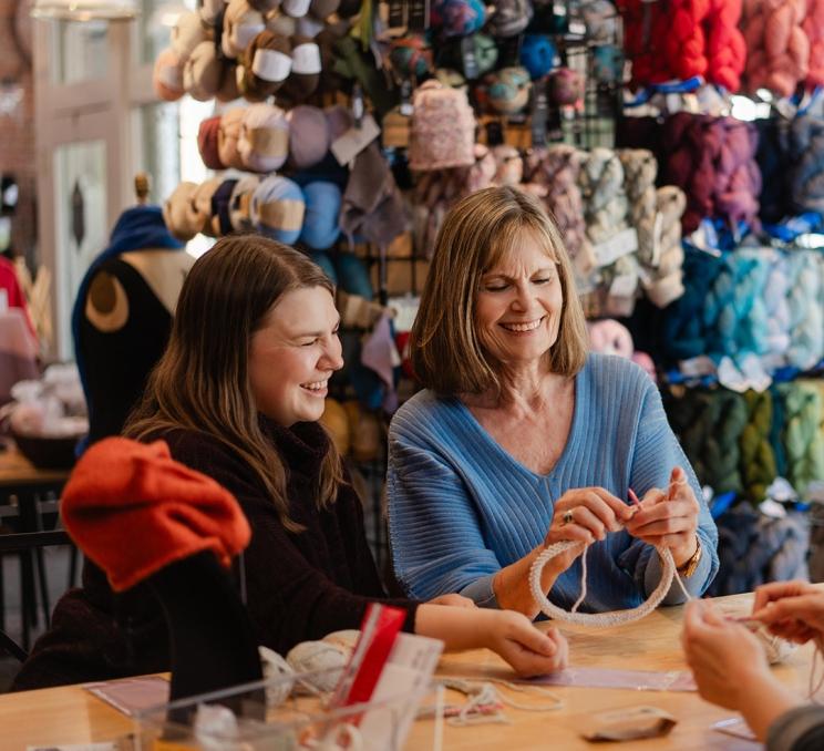 A woman is led through a knitting workshop at Beehive Wool Shop in Victoria, BC