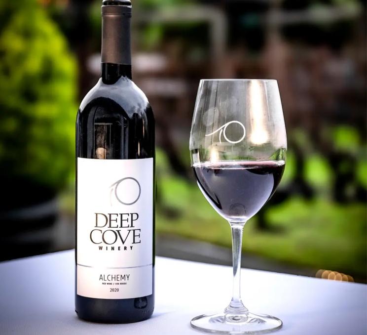 A bottle of wine and a glass of wine on a table at Deep Cove Winery in North Saanich, Greater Victoria, BC