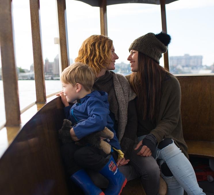 A family rides a Harbour Ferry across the Inner Harbour in Victoria, BC