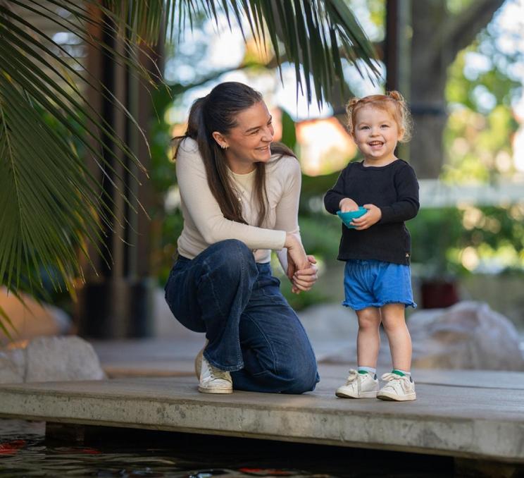 A mom and daughter feed the koi fish at the Parkside Hotel & Spa in Victoria, BC
