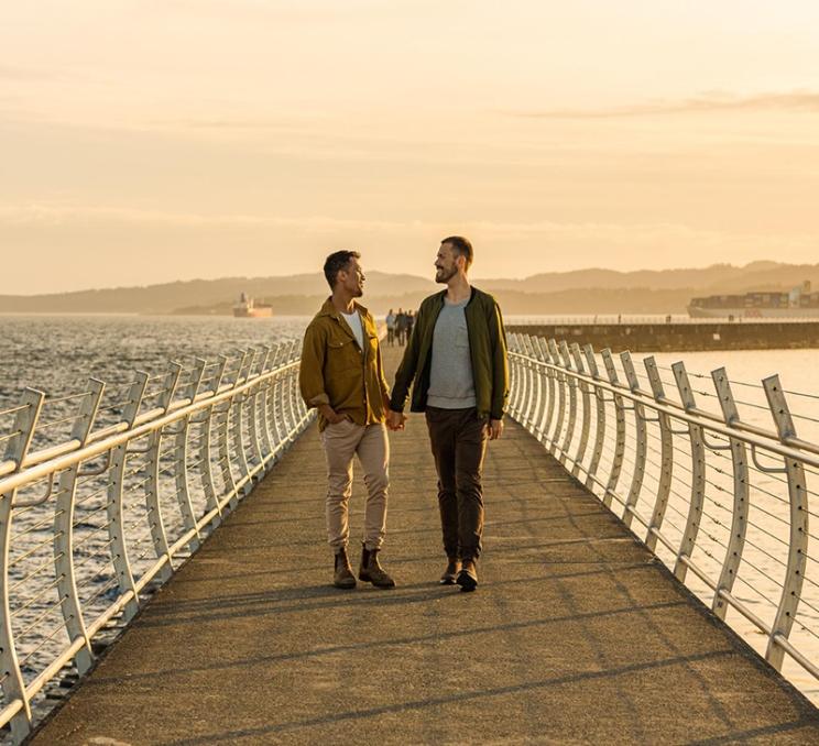 A couple walks along the Ogden Point Breakwater in Victoria, BC