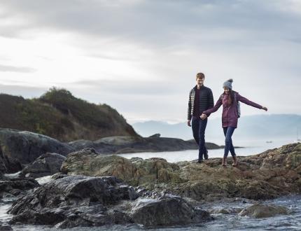 a young couple walking along the shoreline in Victoria, BC