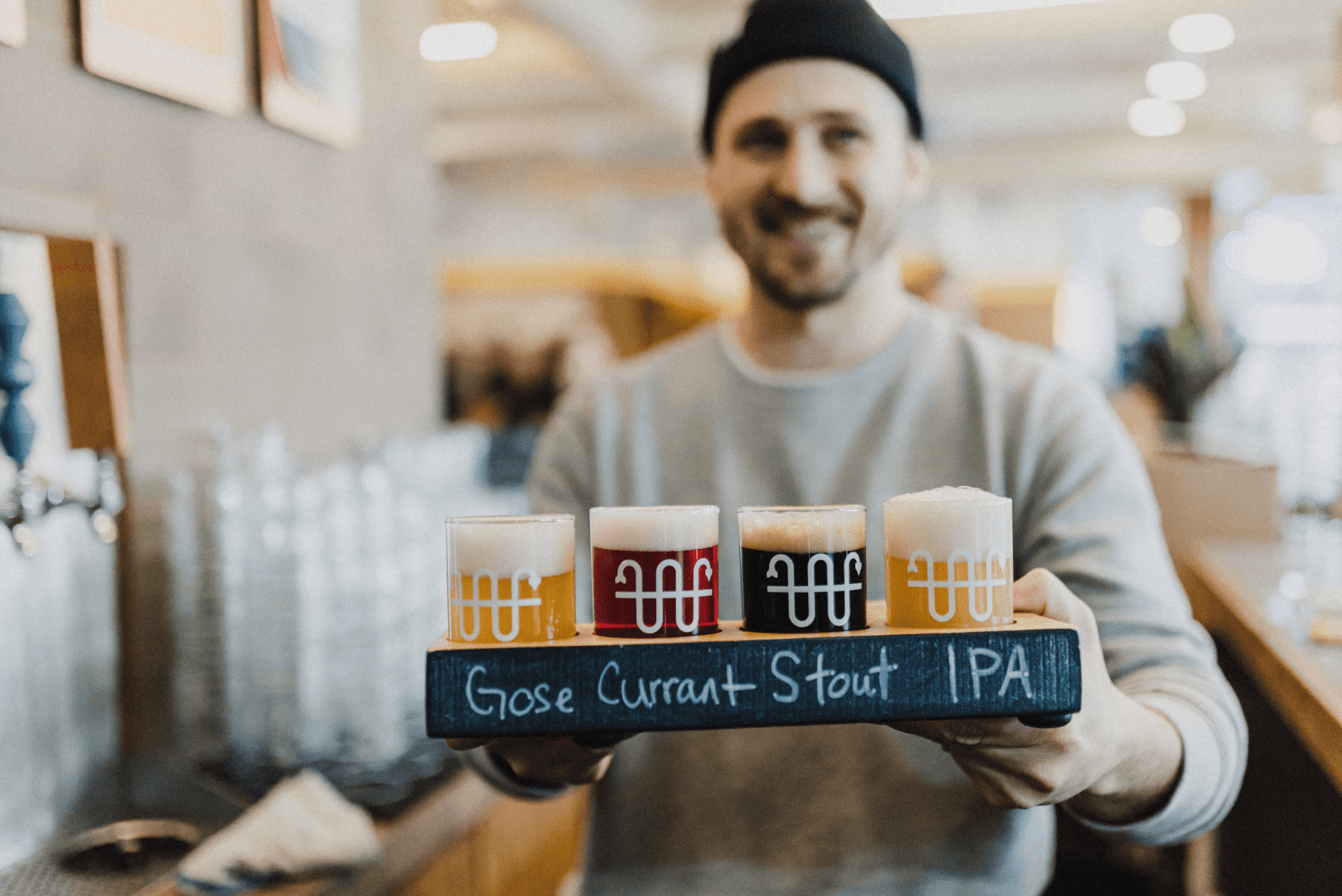 A person holding a flight of beers at Buoy Brewing in Victoria, BC