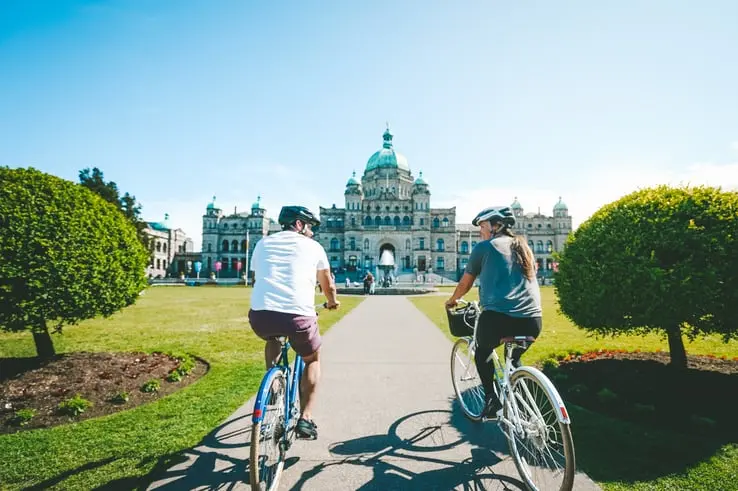 A pair of cyclists at the BC Legislature Parliament Buildings