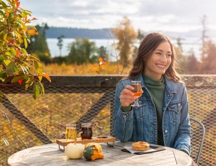 a woman enjoying cider in the fall