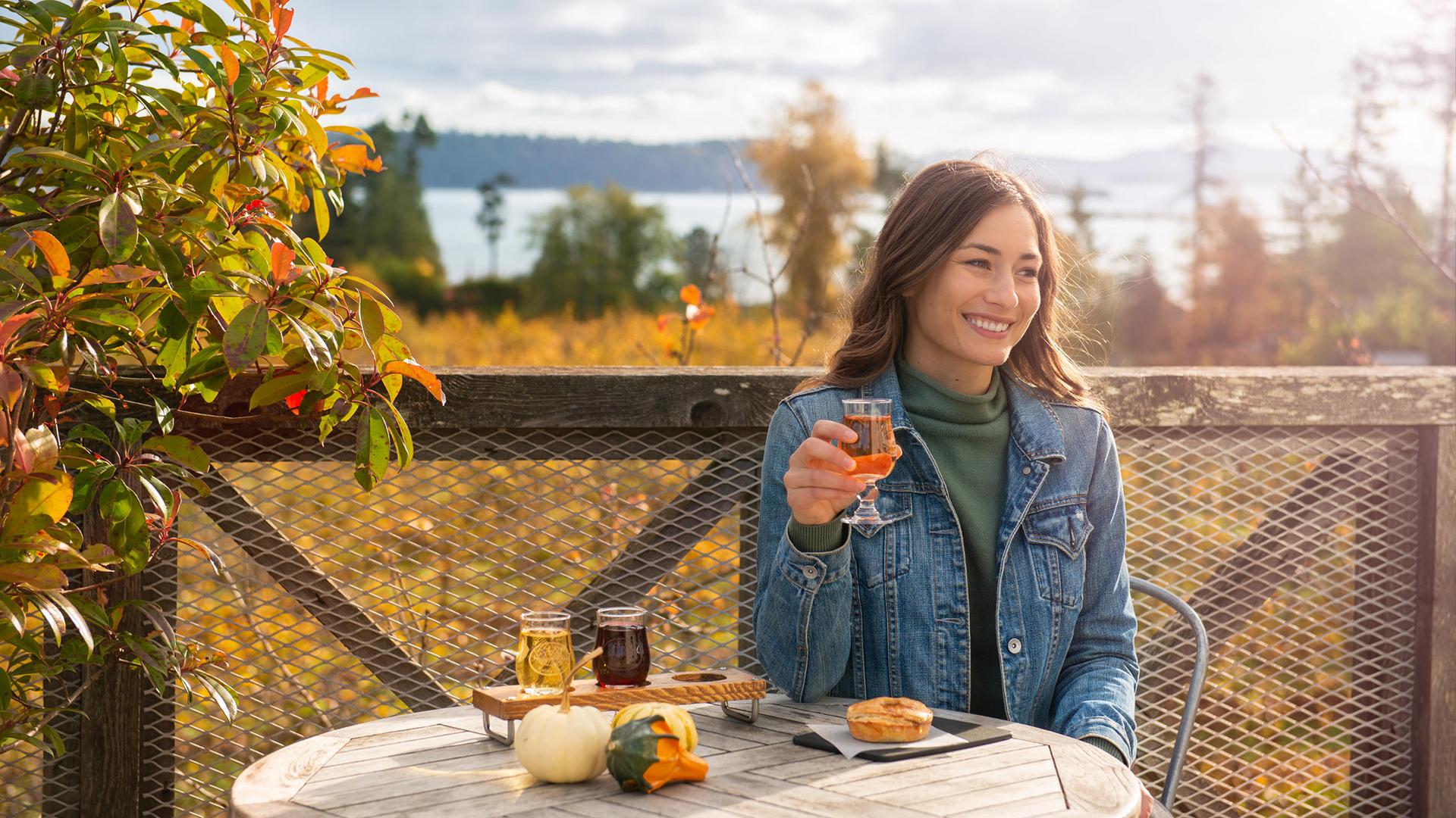 a woman enjoying cider in the fall