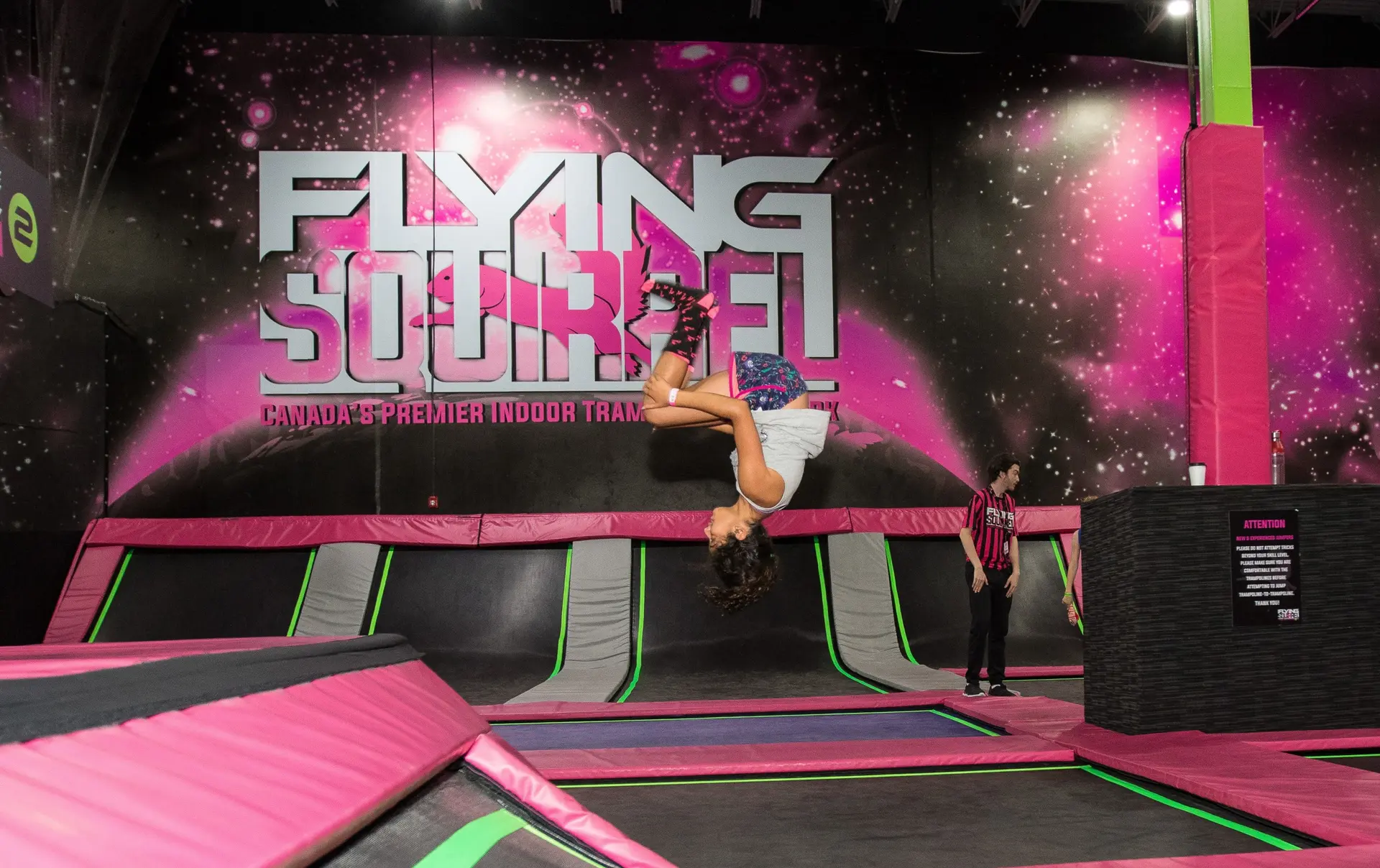 A child flips over in the air during a fun session at Flying Squirrel trampoline park