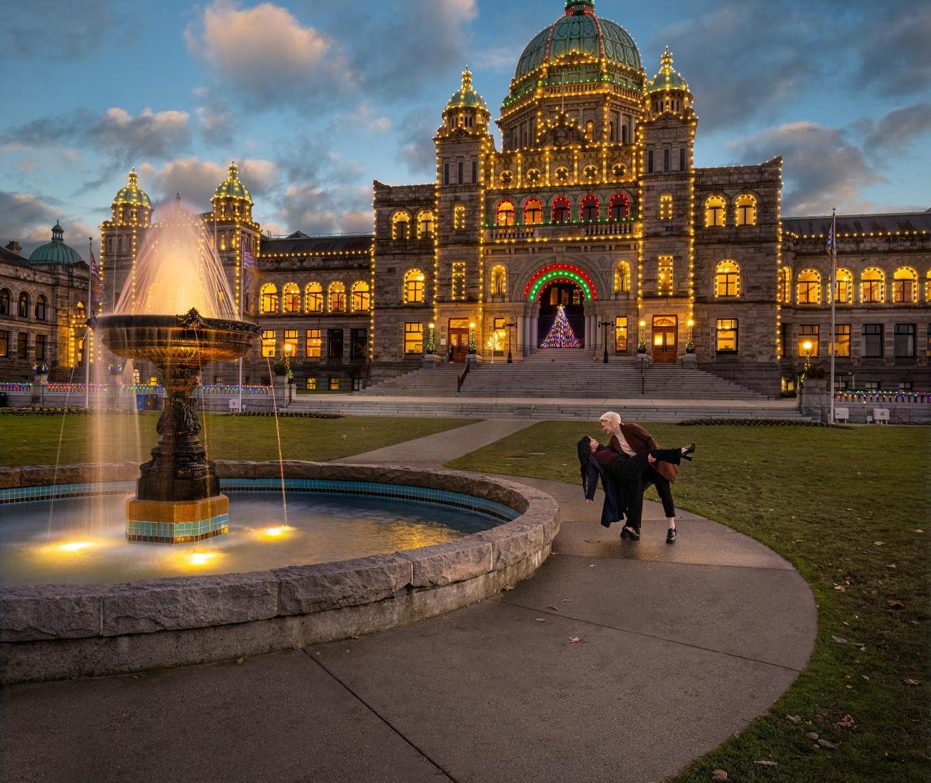 A couple walking in front of the legislature building in Victoria, BC