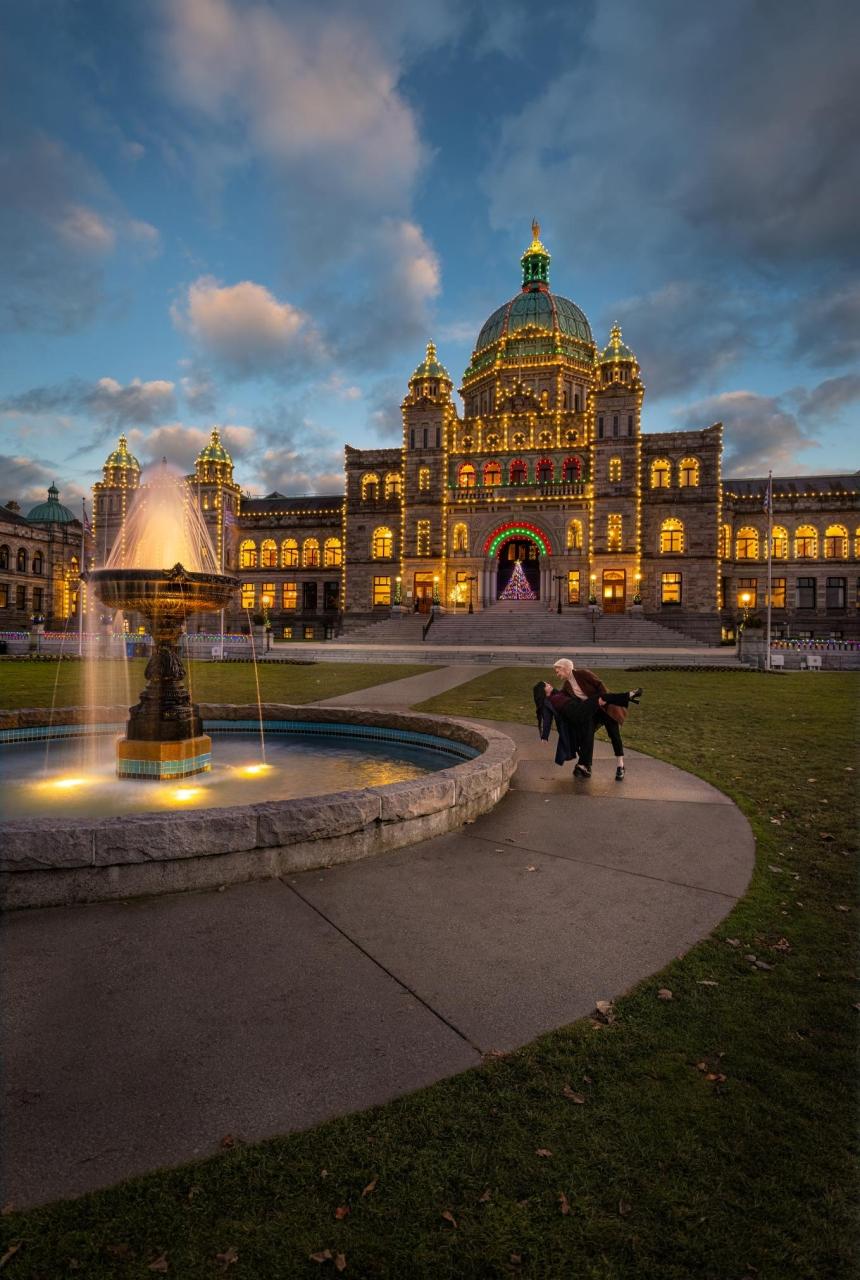 A couple walking in front of the legislature building in Victoria, BC