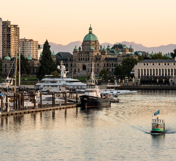 A ferry sailing in front of the BC Parliament Building in the Inner Harbour, Victoria, BC