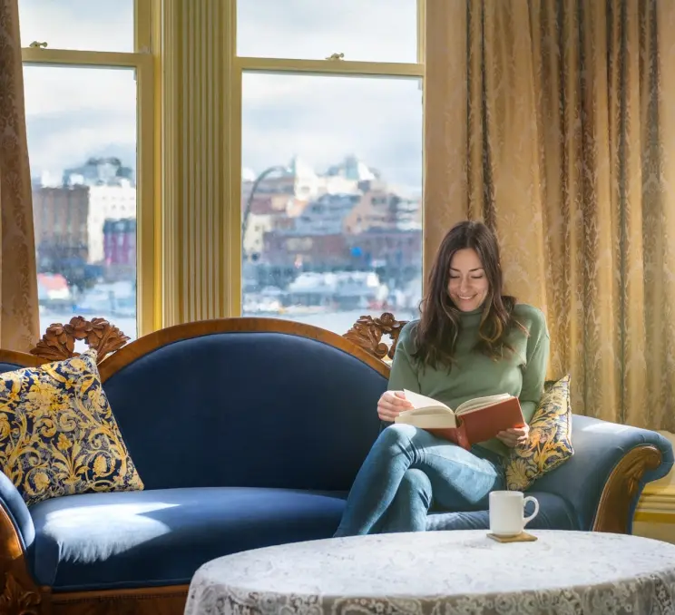 A woman reading a book at Pendray Inn and Tea House in Victoria, BC