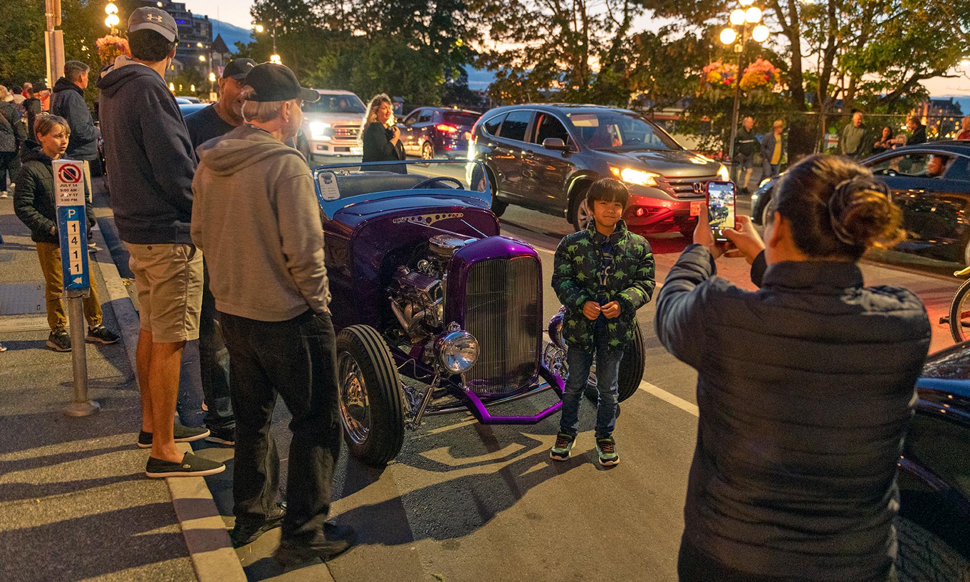 A child gets their photo taken alongside a deuce at Northwest Deuce Days in Victoria, BC