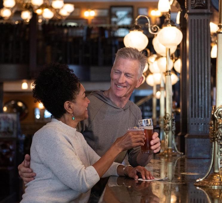 A couple enjoys a drink at the Bard & Banker, a local pub inside a Heritage Building, in Victoria, BC