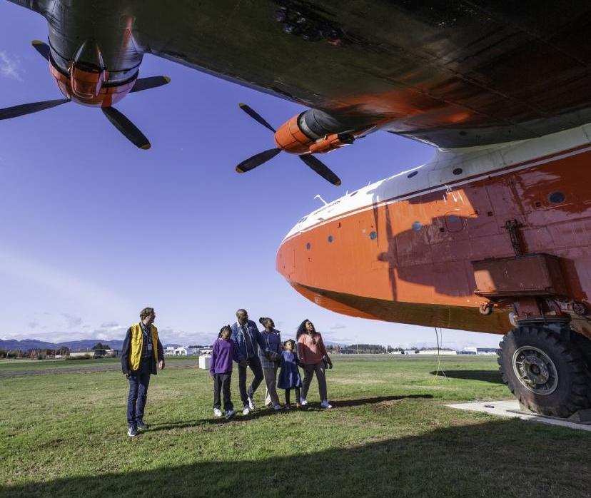 A family inspects a water bomber aircraft at the BC Aviation Museum during a guided tour in Victoria, BC