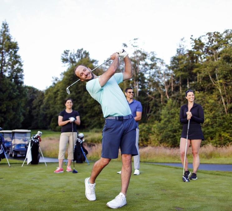 A group of golfers tee off at a golf course in Victoria, BC